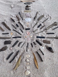 a group of sticks arranged in a circle on the sand